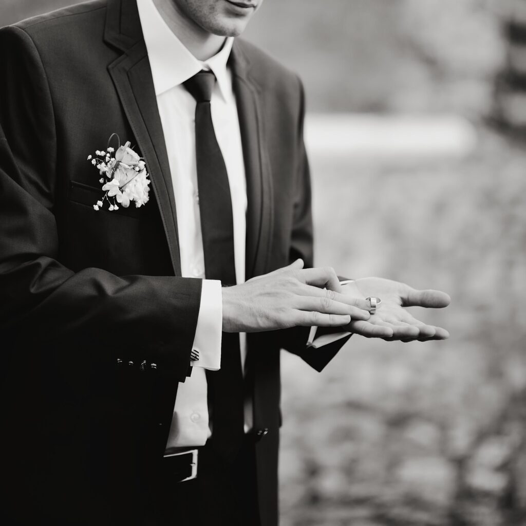 El novio muestra dos anillos de boda en la palma de su mano en castellon